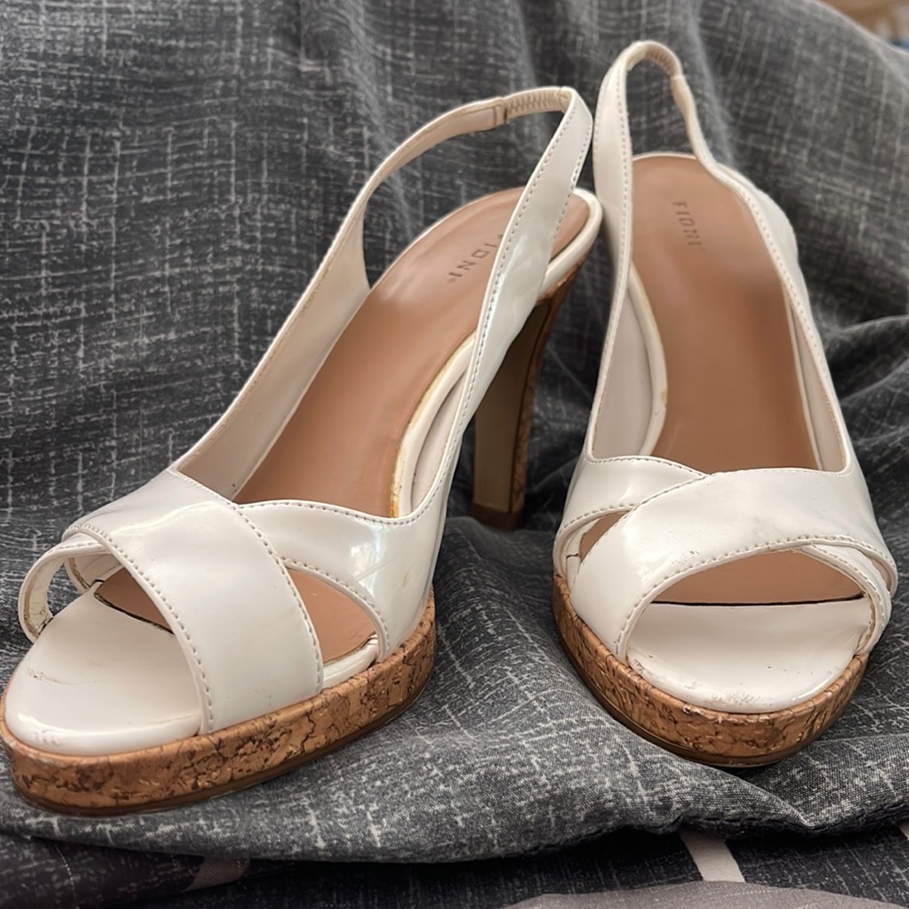 Fioni sling back open toe shoe featuring a four inch cork heel.